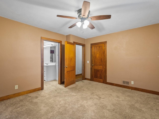 512 S Elida St, Winnebago, IL 61088 - unfurnished bedroom with light carpet, connected bathroom, and ceiling fan