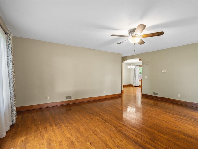 512 S Elida St, Winnebago, IL 61088 - empty room with arched walkways, a ceiling fan, a chandelier, and wood finished floors