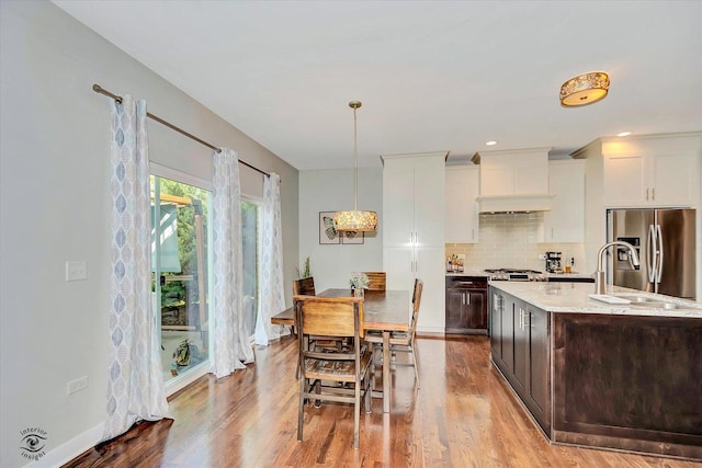 24401 S Clydesdale Ct, Manhattan, IL 60442 - kitchen featuring stainless steel refrigerator with ice dispenser, tasteful backsplash, dark brown cabinets, wood finished floors, and white cabinetry