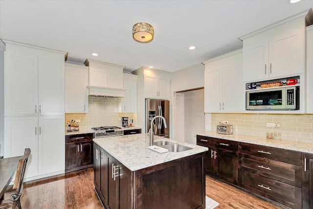 24401 S Clydesdale Ct, Manhattan, IL 60442 - kitchen featuring stainless steel appliances, wood finished floors, backsplash, an island with sink, and dark brown cabinetry