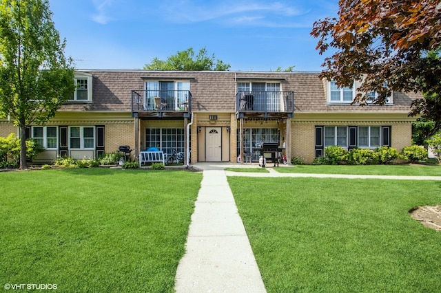1111 Pleasant Run Dr Unit 905, Wheeling, IL 60090 - front facade with mansard roof, brick siding, a shingled roof, and a front lawn