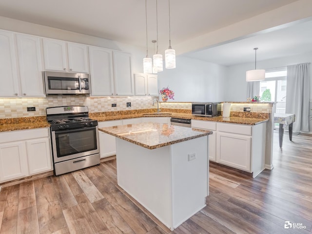424 Grape Vine Trl, Oswego, IL 60543 - kitchen featuring appliances with stainless steel finishes, a peninsula, light wood-style flooring, and white cabinetry