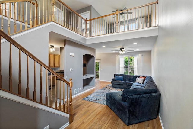 627 S Jade Ln, Round Lake, IL 60073 - living area with stairway, a towering ceiling, wood finished floors, and ceiling fan