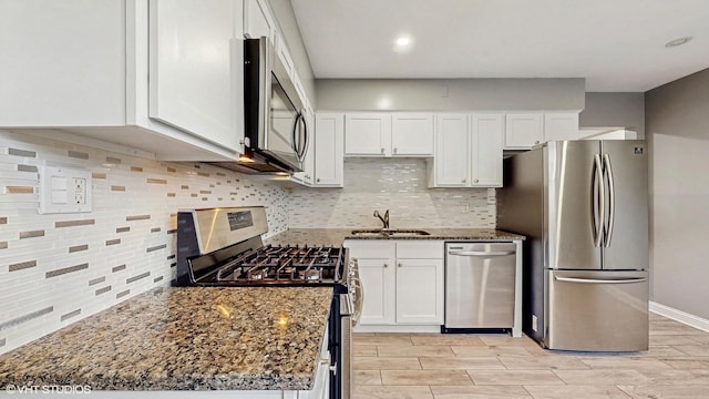 4629 Main St Unit 2A, Skokie, IL 60076 - kitchen with stainless steel appliances, white cabinetry, dark stone counters, tasteful backsplash, and wood finish floors