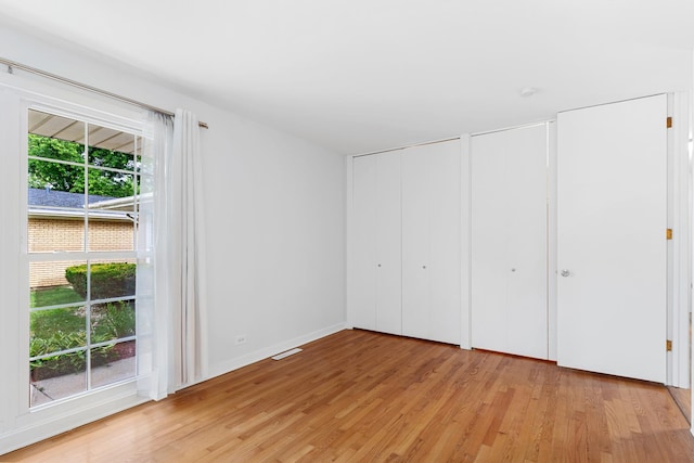 5475 Adeline Pl, Oak Forest, IL 60452 - unfurnished bedroom with light wood finished floors, two closets, and access to exterior