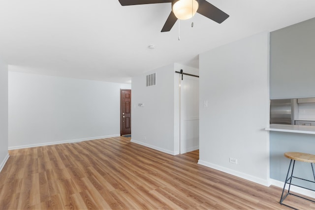 5475 Adeline Pl, Oak Forest, IL 60452 - unfurnished living room with a barn door, ceiling fan, and light wood-style flooring