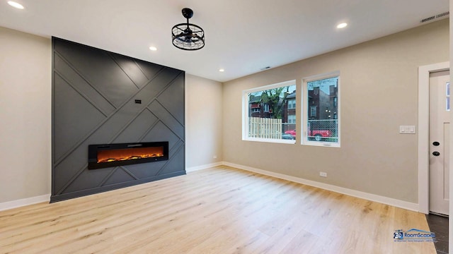 300 N Lockwood Ave, Chicago, IL 60644 - unfurnished living room featuring wood finished floors, a large fireplace, and recessed lighting