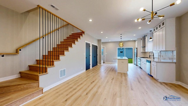 300 N Lockwood Ave, Chicago, IL 60644 - kitchen featuring stainless steel appliances, a kitchen island, light wood-style floors, white cabinetry, and recessed lighting