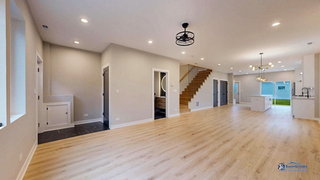 300 N Lockwood Ave, Chicago, IL 60644 - unfurnished living room featuring light wood-style floors, recessed lighting, stairway, and a chandelier