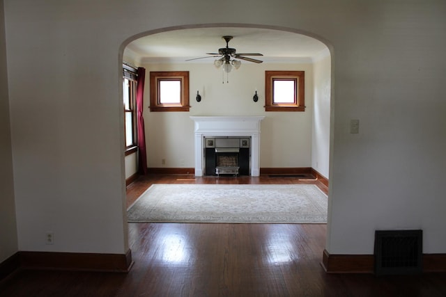 316 Marguerite St, Elgin, IL 60123 - unfurnished living room featuring a fireplace with flush hearth, a ceiling fan, arched walkways, wood finished floors, and ornamental molding