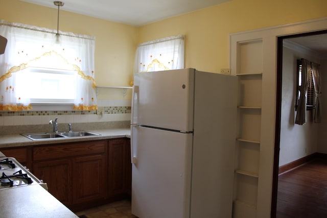 316 Marguerite St, Elgin, IL 60123 - kitchen featuring freestanding refrigerator, brown cabinetry, tasteful backsplash, and light countertops