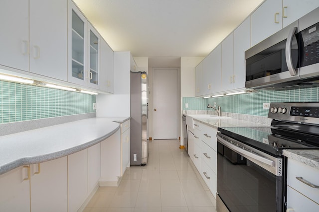 360 E Randolph St Unit 503, Chicago, IL 60601 - kitchen featuring appliances with stainless steel finishes, decorative backsplash, light countertops, and glass insert cabinets