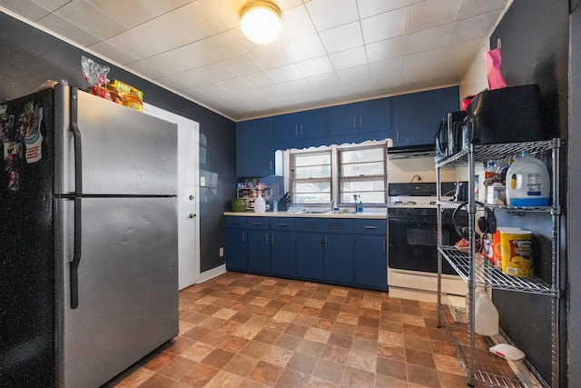 208 Frank Ave, Joliet, IL 60435 - kitchen with freestanding refrigerator, blue cabinets, stove, light countertops, and light stone finish floors