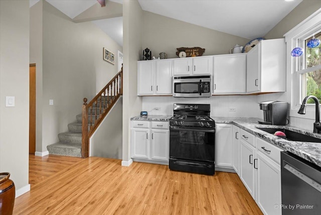 2519 Penn Blvd, Lindenhurst, IL 60046 - kitchen featuring appliances with stainless steel finishes, vaulted ceiling, light wood finished floors, white cabinets, and light stone countertops