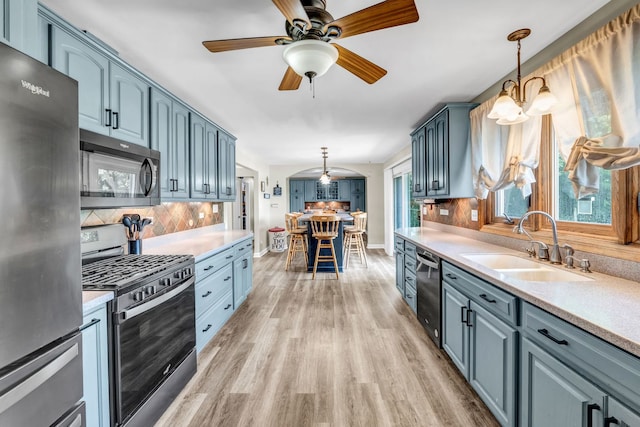 9822 W Pauling Rd, Monee, IL 60449 - kitchen featuring stainless steel appliances, backsplash, light countertops, light wood-style flooring, and pendant lighting