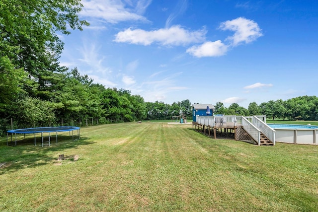 9822 W Pauling Rd, Monee, IL 60449 - view of green lawn with a trampoline, a deck, an outdoor pool, and stairs