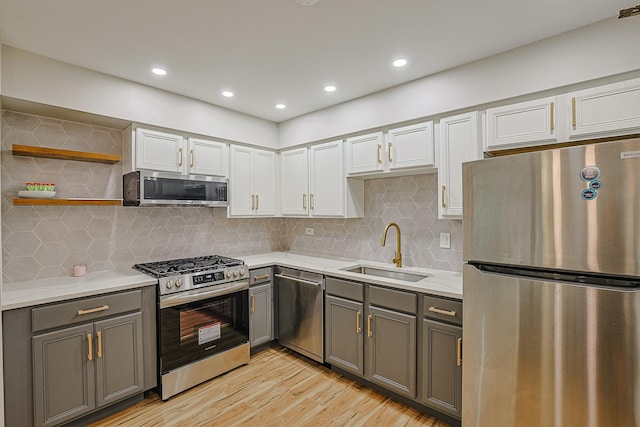 9562 Park Ln Unit 1D, Des Plaines, IL 60016 - kitchen with appliances with stainless steel finishes, gray cabinets, light countertops, light wood finished floors, and white cabinets