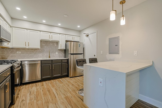 9562 Park Ln Unit 1D, Des Plaines, IL 60016 - kitchen featuring stainless steel appliances, electric panel, light wood-style flooring, white cabinets, and recessed lighting