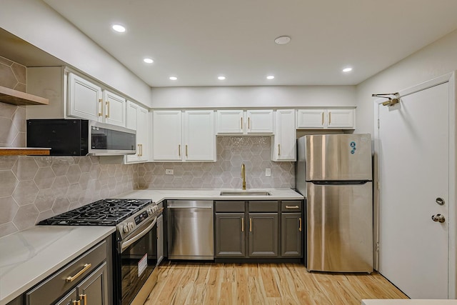 9562 Park Ln Unit 1D, Des Plaines, IL 60016 - kitchen featuring appliances with stainless steel finishes, light wood-style flooring, white cabinets, open shelves, and backsplash