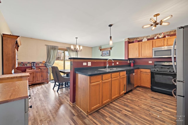 1075 Christine Ln, Antioch, IL 60002 - kitchen with appliances with stainless steel finishes, a chandelier, dark wood finished floors, and a peninsula