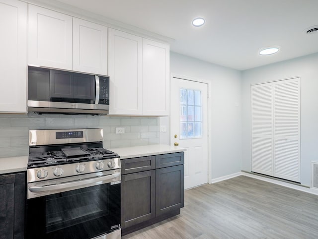 1406 N Artesian Ave, Chicago, IL 60622 - kitchen with stainless steel appliances, light countertops, light wood-style floors, tasteful backsplash, and recessed lighting