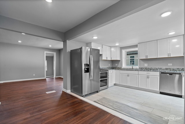 829 Liberty St, Aurora, IL 60505 - kitchen featuring stainless steel appliances, light wood finished floors, white cabinets, light stone countertops, and recessed lighting