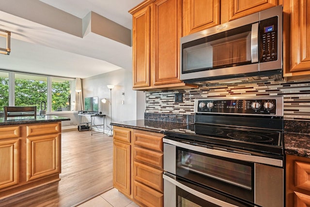 101 Bar Harbour Rd Unit 5N, Schaumburg, IL 60193 - kitchen with appliances with stainless steel finishes, backsplash, dark stone countertops, and brown cabinets