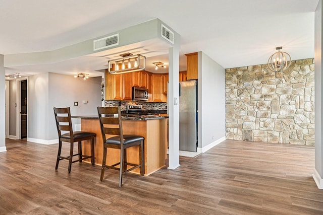 101 Bar Harbour Rd Unit 5N, Schaumburg, IL 60193 - kitchen featuring dark countertops, brown cabinetry, dark wood-style floors, and stainless steel appliances