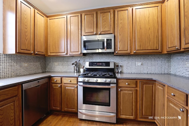 78 Thomas Ct, Grayslake, IL 60030 - kitchen featuring appliances with stainless steel finishes, dark countertops, and brown cabinetry