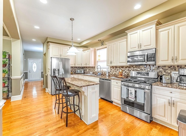 3139 Ridgeland Ave, Berwyn, IL 60402 - kitchen featuring appliances with stainless steel finishes, a kitchen bar, tasteful backsplash, stone countertops, and pendant lighting