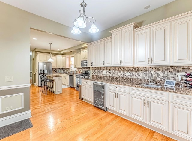 3139 Ridgeland Ave, Berwyn, IL 60402 - kitchen featuring wine cooler, stainless steel appliances, a kitchen bar, dark stone countertops, and decorative light fixtures