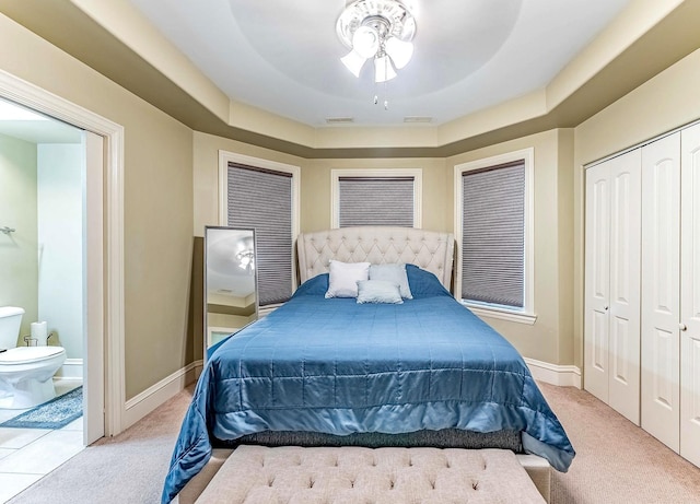 3139 Ridgeland Ave, Berwyn, IL 60402 - carpeted bedroom featuring a closet, connected bathroom, ceiling fan, and a tray ceiling