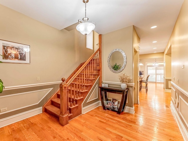 3139 Ridgeland Ave, Berwyn, IL 60402 - staircase with wood finished floors, a chandelier, a decorative wall, wainscoting, and recessed lighting