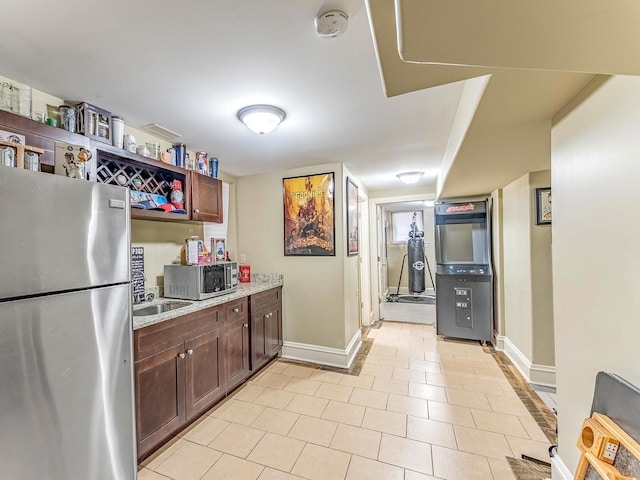 3139 Ridgeland Ave, Berwyn, IL 60402 - kitchen with stainless steel appliances, dark brown cabinets, light stone countertops, and light tile patterned floors