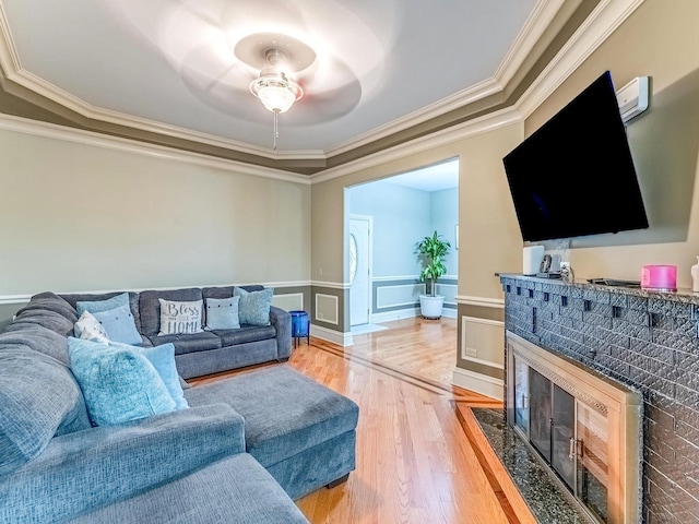 3139 Ridgeland Ave, Berwyn, IL 60402 - living room featuring crown molding, ceiling fan, light wood-style floors, a wainscoted wall, and a fireplace with flush hearth