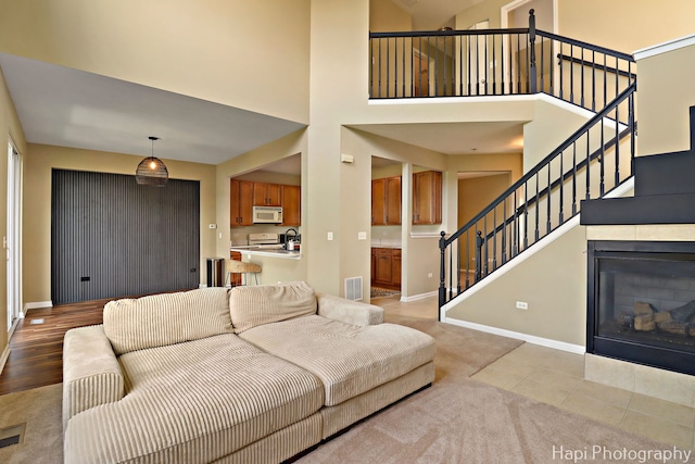 548 Legend Ln, Mchenry, IL 60050 - living room featuring stairway, a towering ceiling, light colored carpet, and a glass covered fireplace