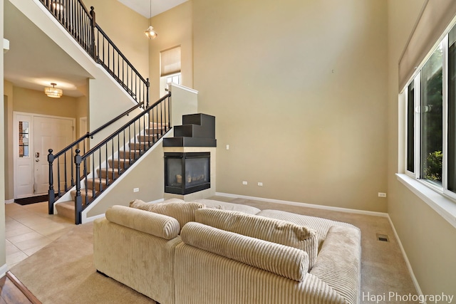548 Legend Ln, Mchenry, IL 60050 - living room featuring a towering ceiling, stairs, a tile fireplace, and tile patterned flooring
