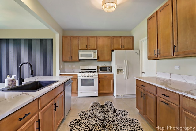 548 Legend Ln, Mchenry, IL 60050 - kitchen featuring appliances with stainless steel finishes, light tile patterned flooring, light stone counters, and brown cabinetry