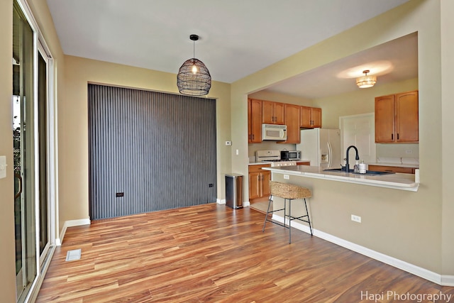 548 Legend Ln, Mchenry, IL 60050 - kitchen with white appliances, light wood finished floors, light countertops, a peninsula, and pendant lighting