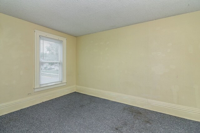 528 5th St, Aurora, IL 60505 - spare room with dark colored carpet and a textured ceiling