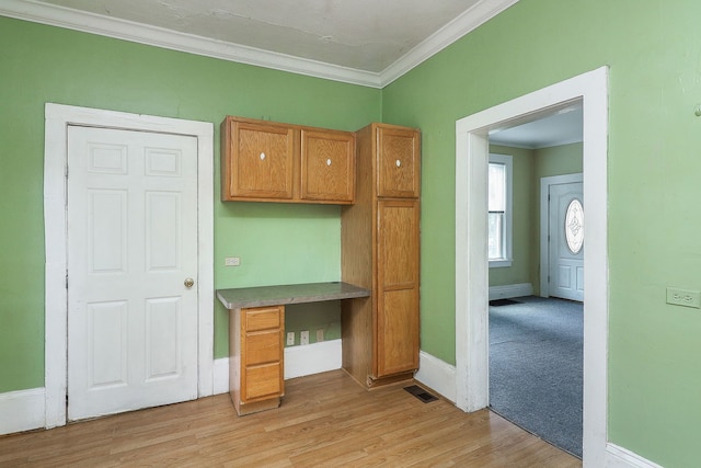 528 5th St, Aurora, IL 60505 - kitchen featuring built in study area, crown molding, light wood-type flooring, and brown cabinetry
