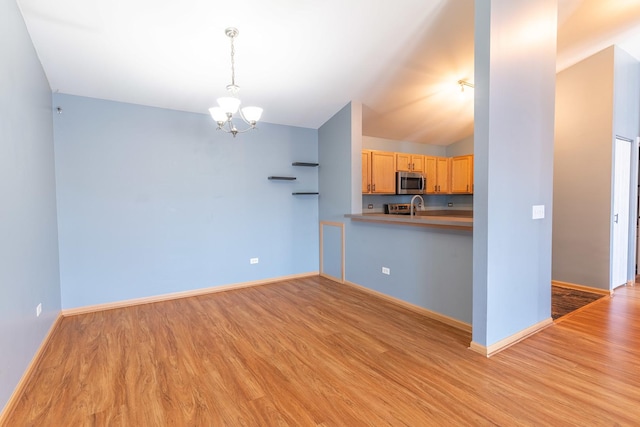 1521 Silverstone Dr Unit 3, Carpentersville, IL 60110 - kitchen featuring light wood finished floors, a chandelier, stainless steel microwave, decorative light fixtures, and light brown cabinetry
