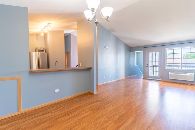 1521 Silverstone Dr Unit 3, Carpentersville, IL 60110 - unfurnished living room featuring wood finished floors, a chandelier, vaulted ceiling, and a wall unit AC