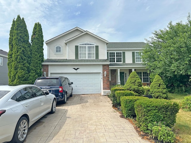 6814 Sahara Dr, Plainfield, IL 60586 - traditional-style house with decorative driveway, brick siding, an attached garage, and roof with shingles