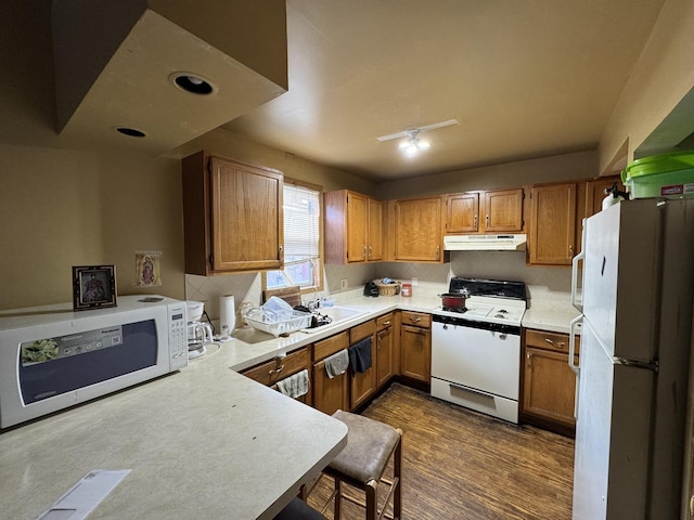 368 N Hickory St, Joliet, IL 60435 - kitchen with white appliances, under cabinet range hood, brown cabinetry, and decorative backsplash