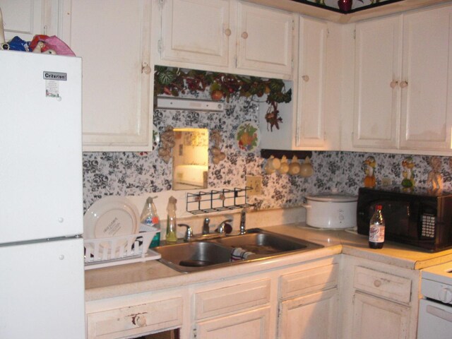 513 Overland Trl, Rockford, IL 61101 - kitchen with freestanding refrigerator, light countertops, black microwave, white cabinetry, and wallpapered walls
