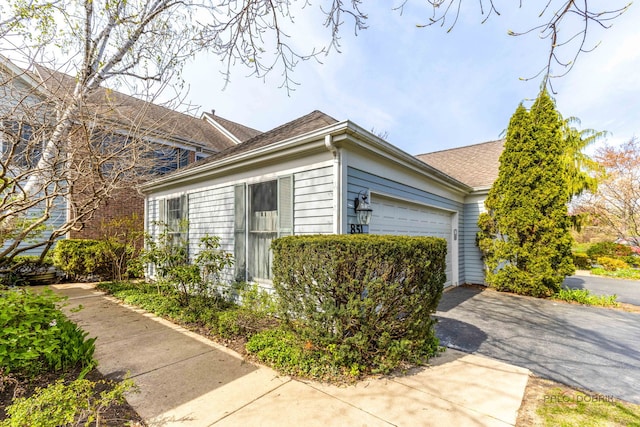 851 Sutton Ct, Lincolnshire, IL 60069 - view of side of home with a garage, a shingled roof, and driveway
