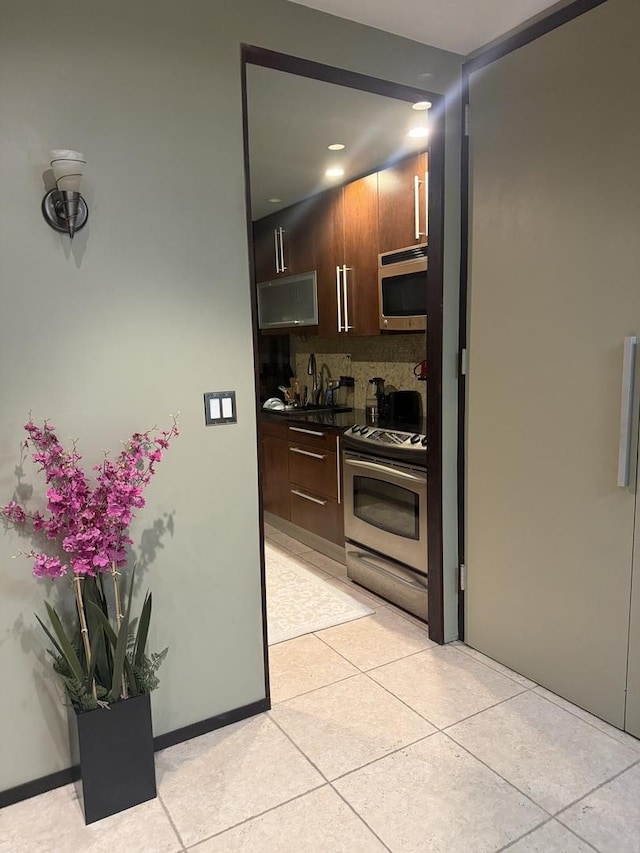 1300 N Astor St Unit 6B, Chicago, IL 60610 - kitchen featuring appliances with stainless steel finishes, dark countertops, decorative backsplash, light tile patterned flooring, and recessed lighting