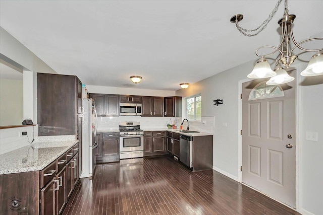 1112 Kim Ct, Joliet, IL 60431 - kitchen with stainless steel appliances, tasteful backsplash, dark brown cabinets, a chandelier, and dark wood-type flooring