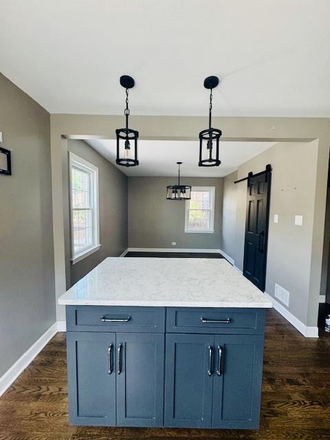 2544 W 107th St, Chicago, IL 60655 - kitchen with dark wood-style flooring, decorative light fixtures, a barn door, and a center island